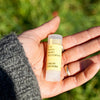 Hand holding a Fresh Pickins Farm Mint Rosemary Lip Balm 