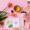 Fresh Pickins Farm products and flowers on a pink background