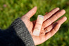 Hand holding a Fresh Pickins Farm Organic beeswax lip balm tube