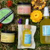 Collection of Fresh Pickins Farm organic skincare products on grass with flowers