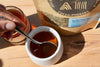 spoon drizzling raw Maine wildflower honey into tea